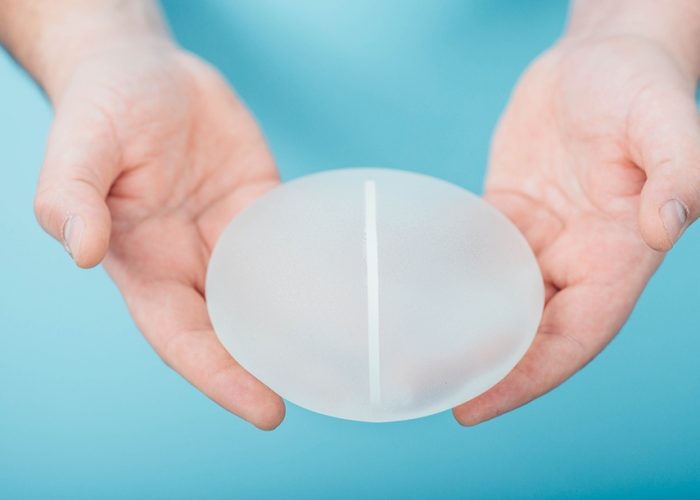 plastic surgeon holding breast silicone implant, crop silicone implant close-up. Augmentation breast size, breast Surgery.